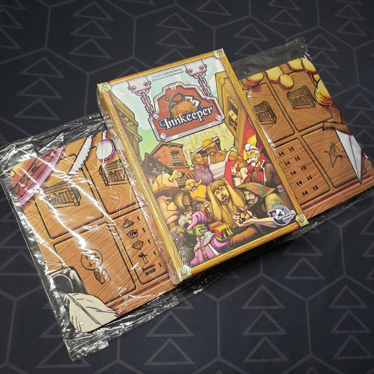 Image shows the front cover of the box for the Innkeeper card game sitting on top of a pack of game mats