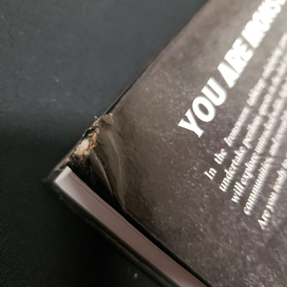 Image shows corner damage on backside of the core rulebook for the roleplaying game Ironsworn