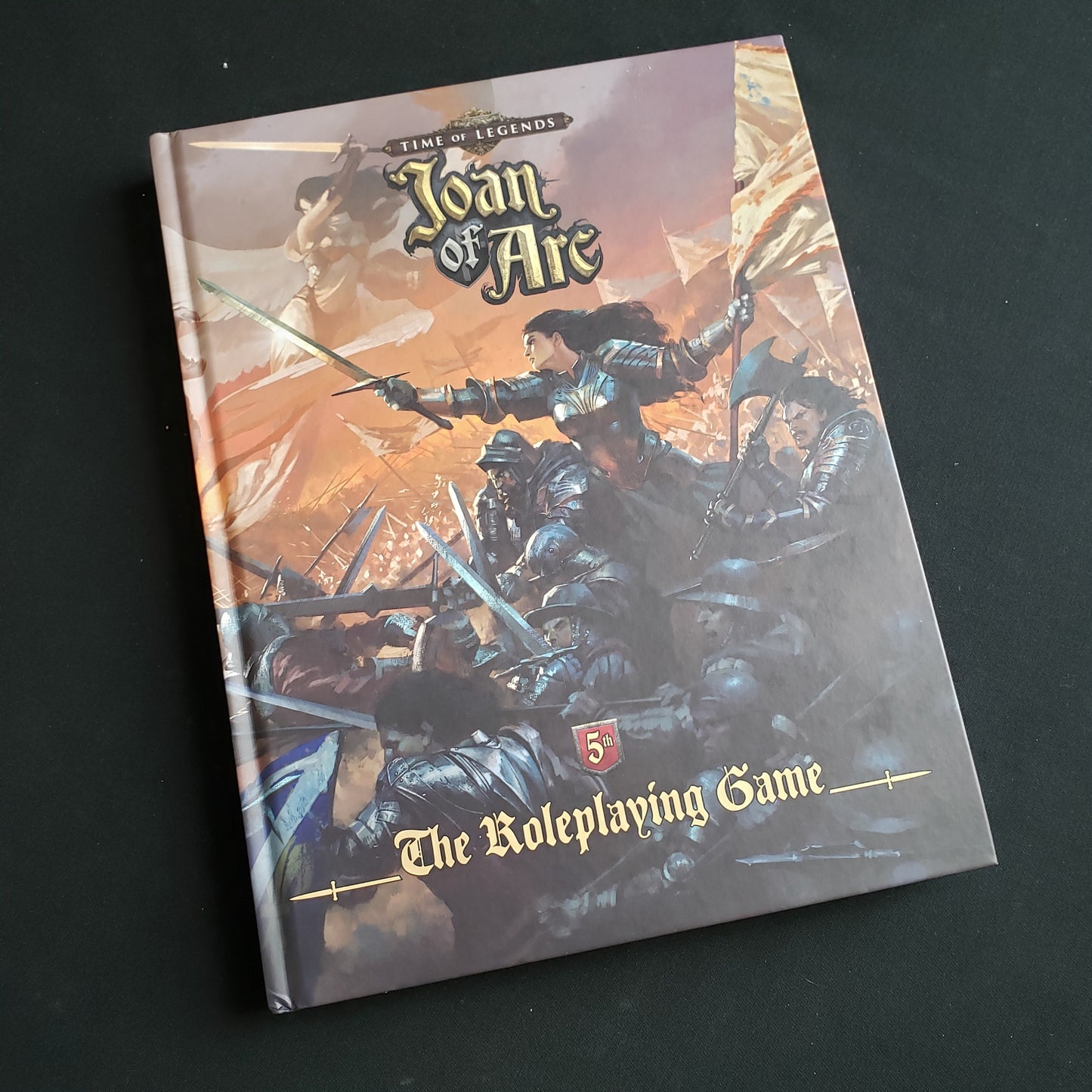 Image shows the front cover of the core rulebook for the Joan of Arc roleplaying game