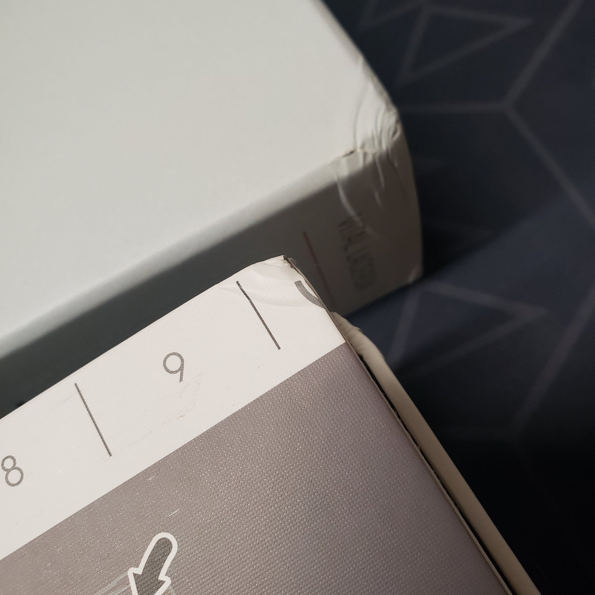 Image shows a dinged corner of the box  and a matching corner ding on the board for the Kanban EV board game