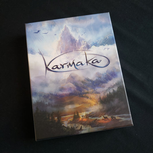 Image shows the front cover of the box of the Karmaka card game