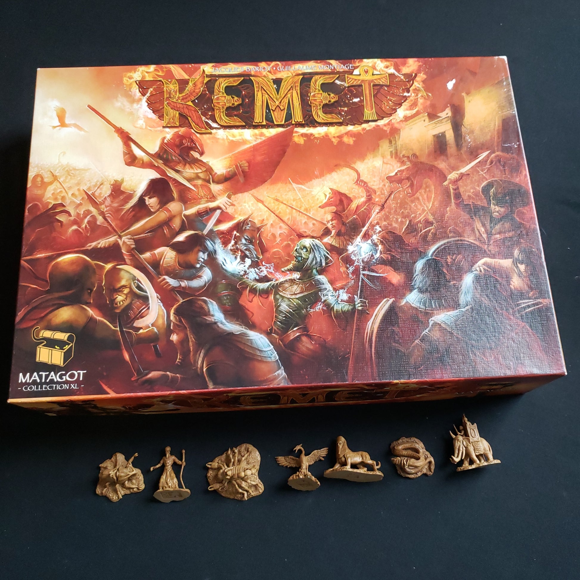 Image shows the front cover of the box of the Kemet board game, with the Creature miniatures underneath it