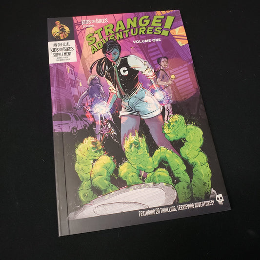 Image shows the front cover of the Strange Adventures! Vol. 1 book for the roleplaying game Kids on Bikes