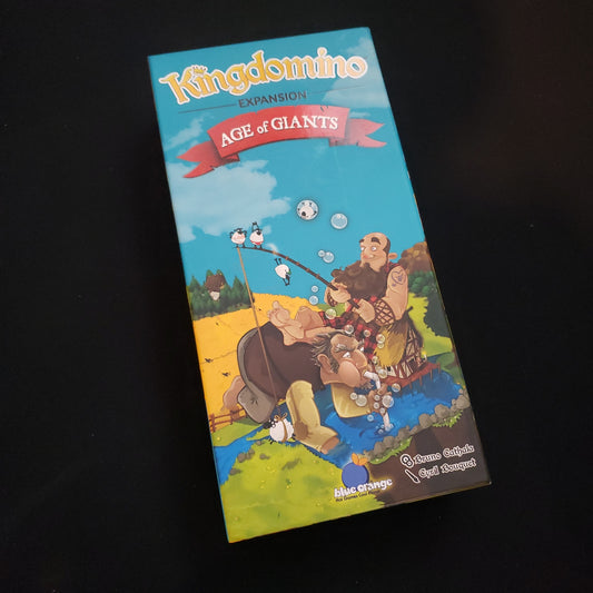 Image shows the front cover of the box of the Age of Giants expansion for the board game Kingdomino
