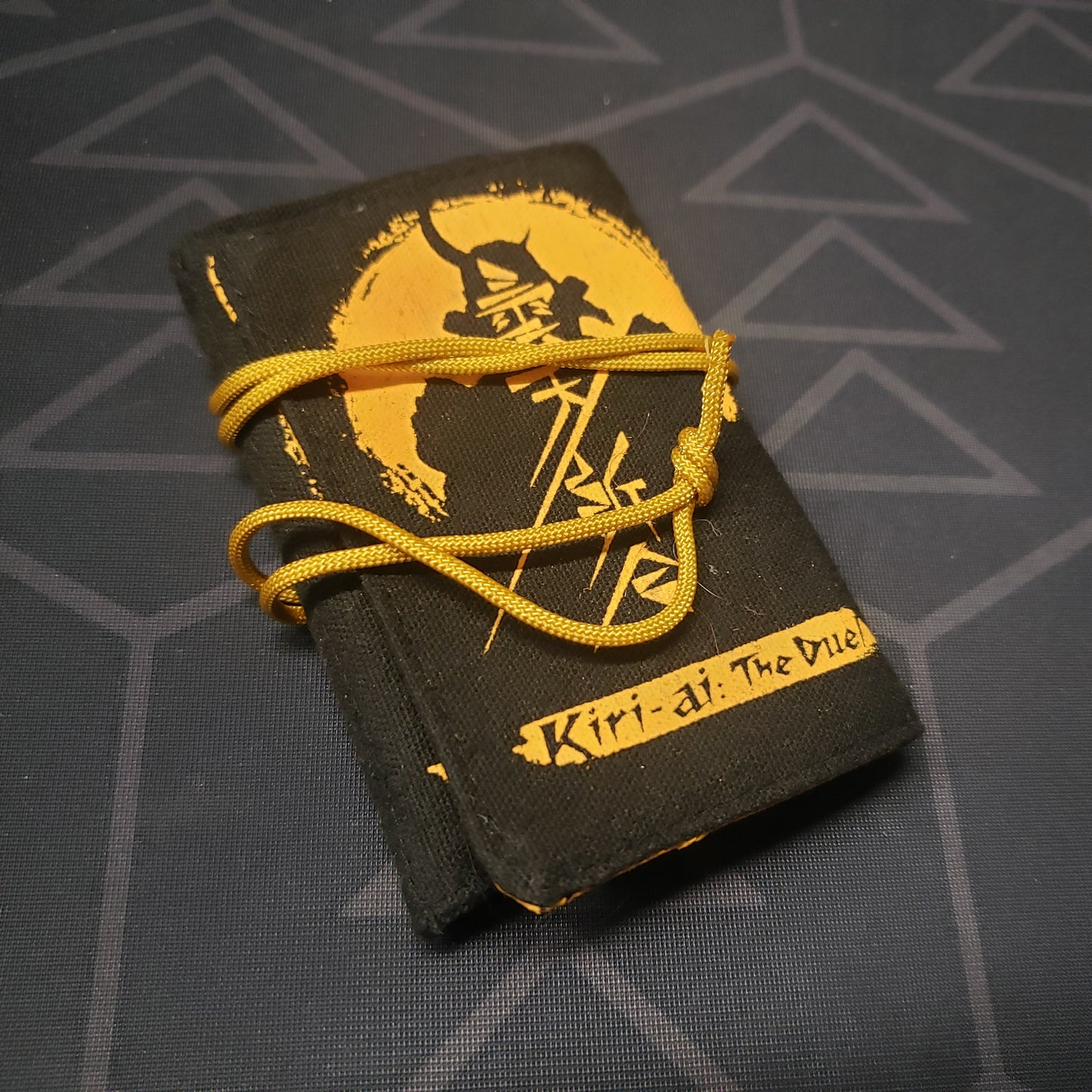 Image shows the front of the cloth carrying case for the card game Kiri-ai: The Duel