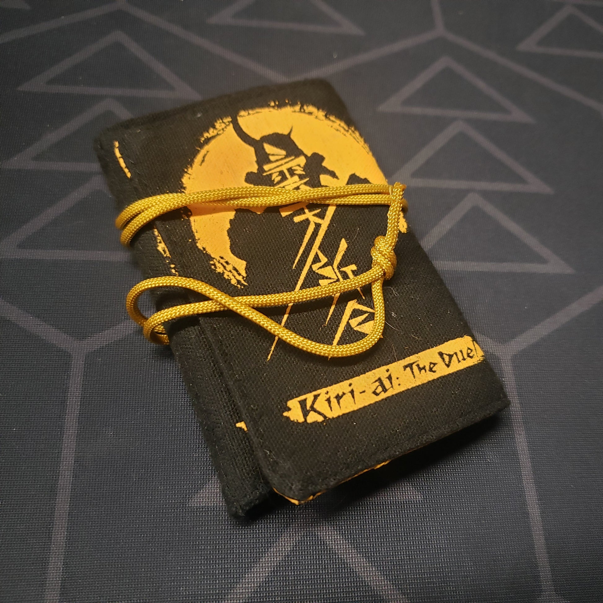 Image shows the front of the cloth carrying case for the card game Kiri-ai: The Duel