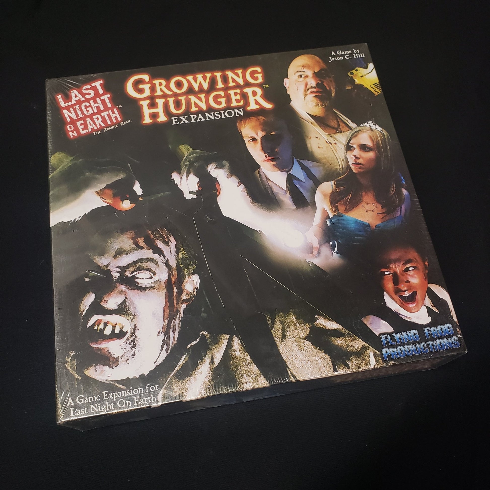 Image shows the front cover of the box of the Growing Hunger expansion for the board game Last Night on Earth