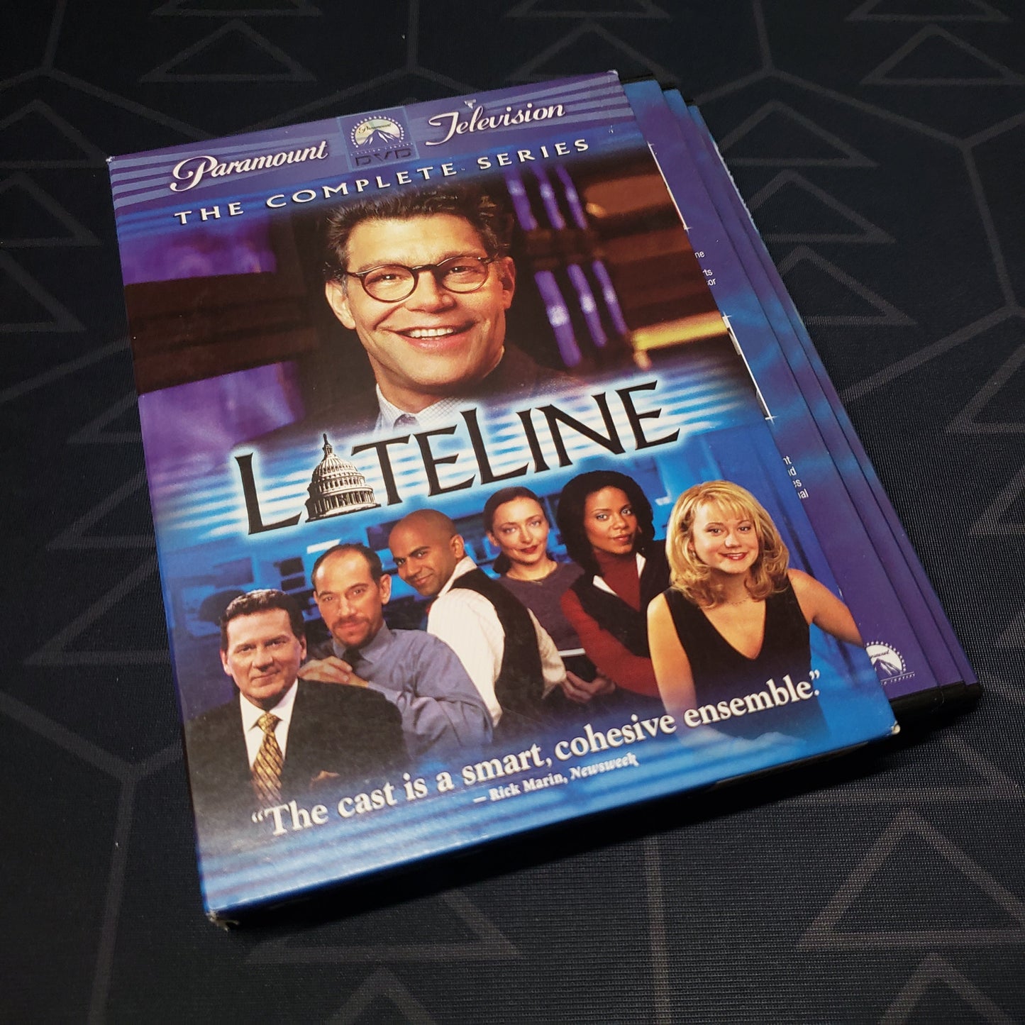 Image shows the outer box with disc cases fanned out for the complete series box set of the tv show Lateline