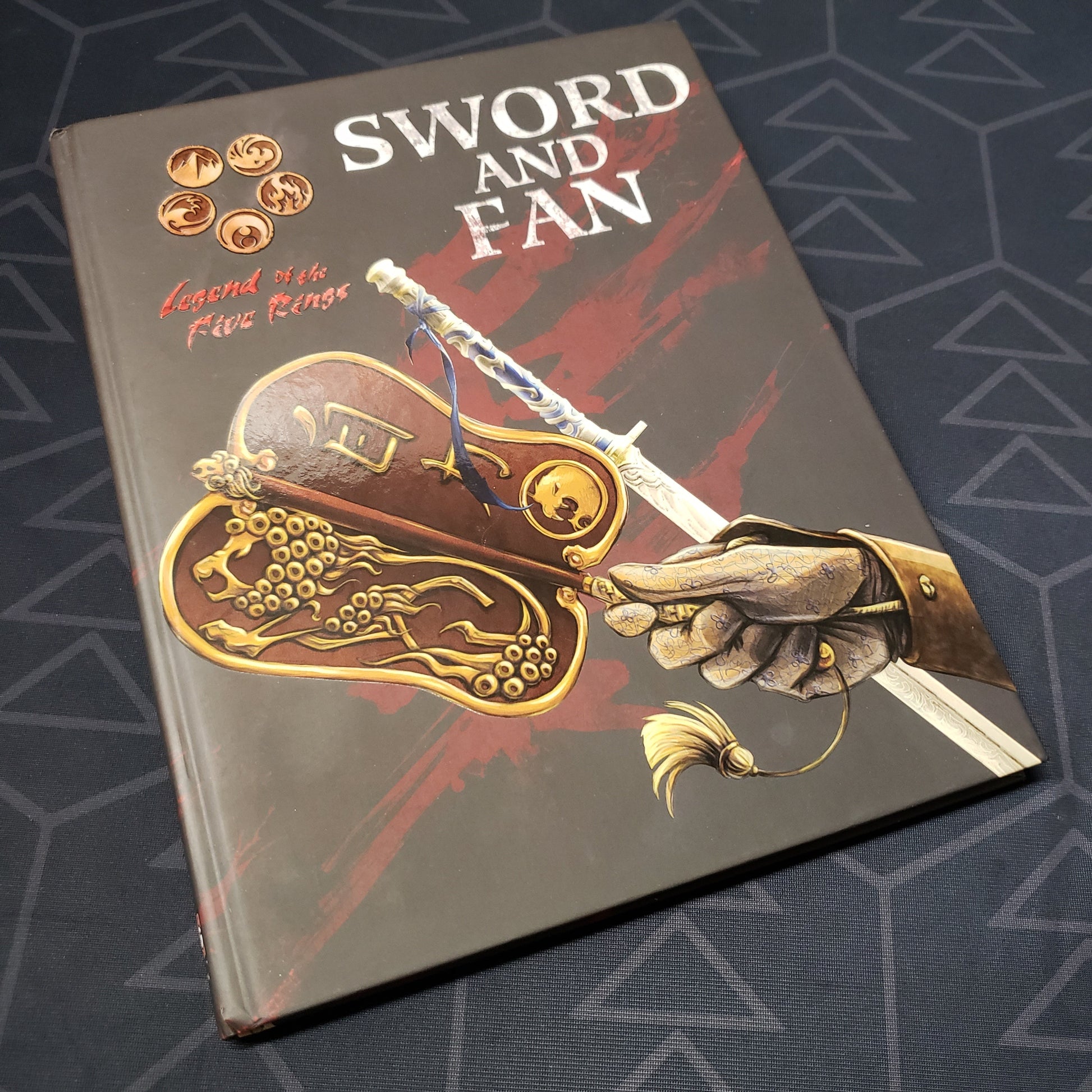 Image shows the front cover of the Sword and Fan book for the roleplaying game Legend of the Five Rings: Fourth Edition