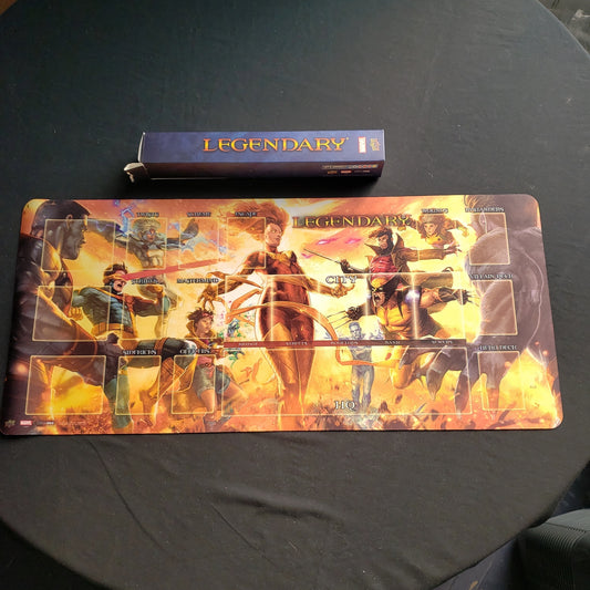 Image shows the Dark Phoenix vs the X-Men art playmat for the Legendary Marvel card game, with the original box sitting above it