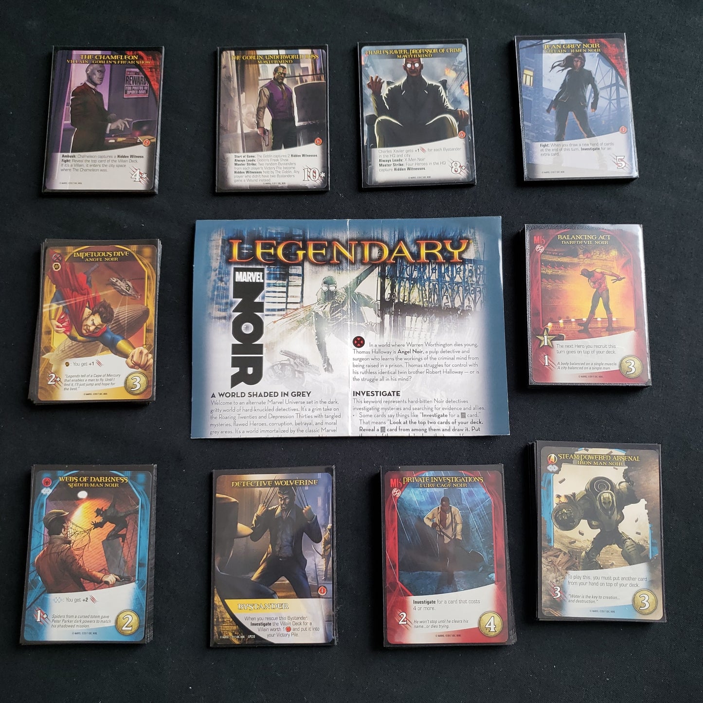 Image shows the instructions & cards arranged in stacks by card type for the Noir expansion for the board game Legendary Marvel