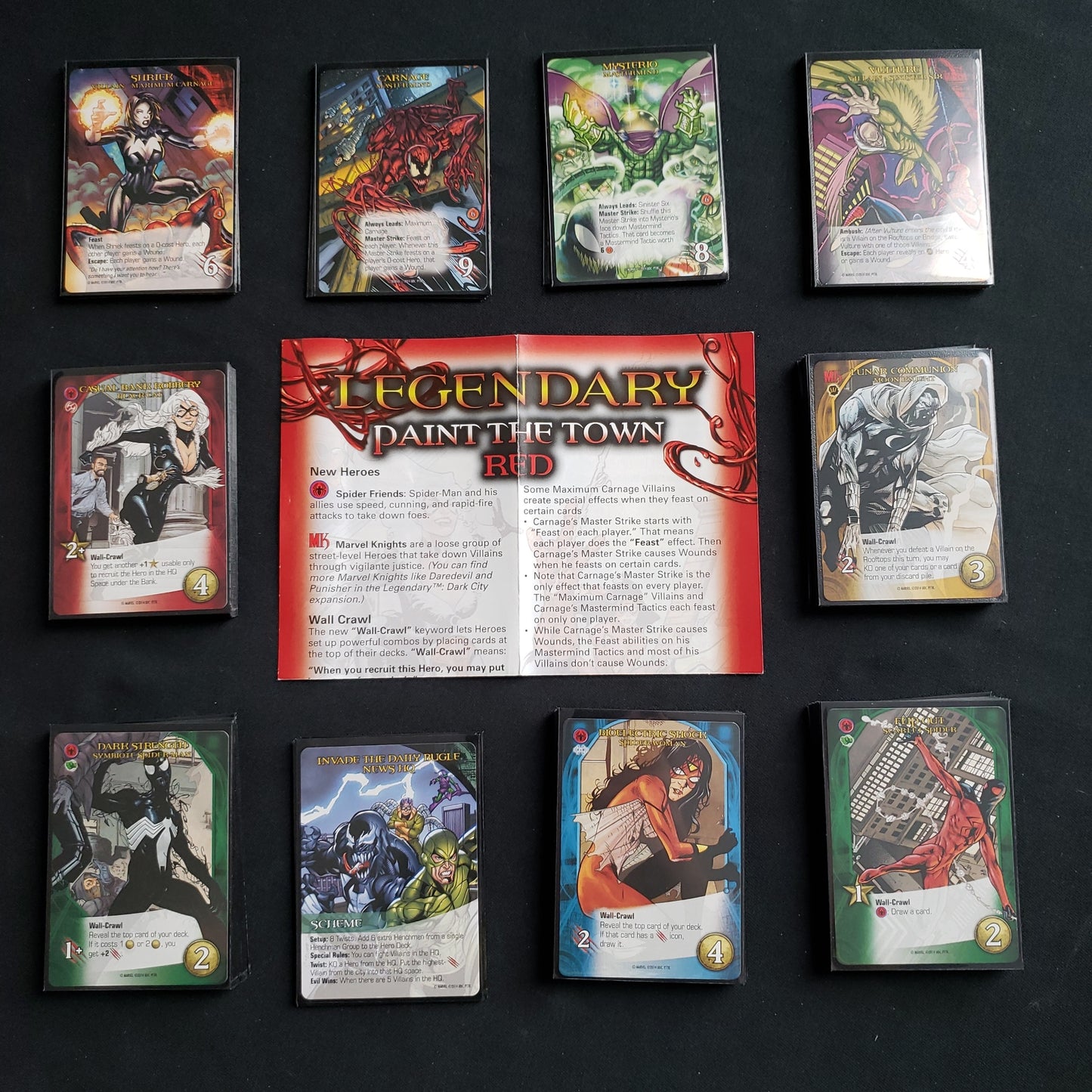 Image shows the instructions & cards arranged in stacks by card type for the Paint the Town Red expansion for the board game Legendary Marvel