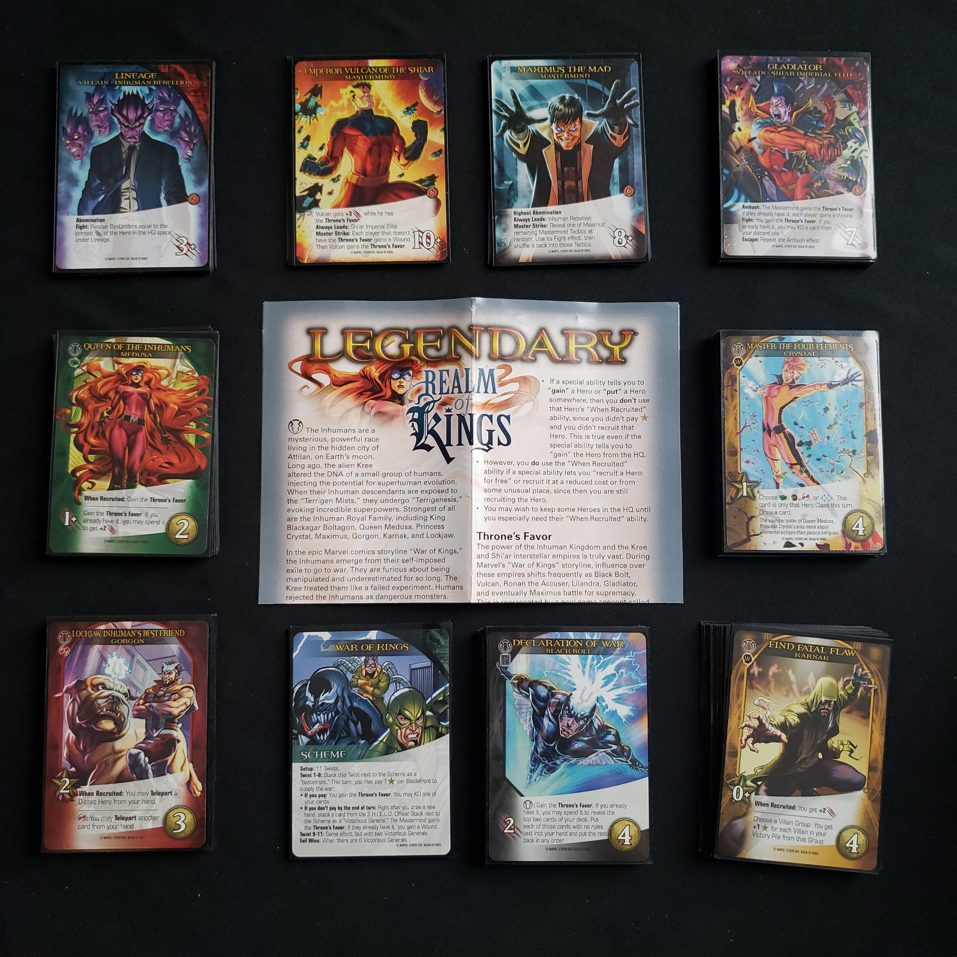 Image shows the instructions & cards arranged in stacks by card type for the Realm of Kings expansion for the board game Legendary Marvel