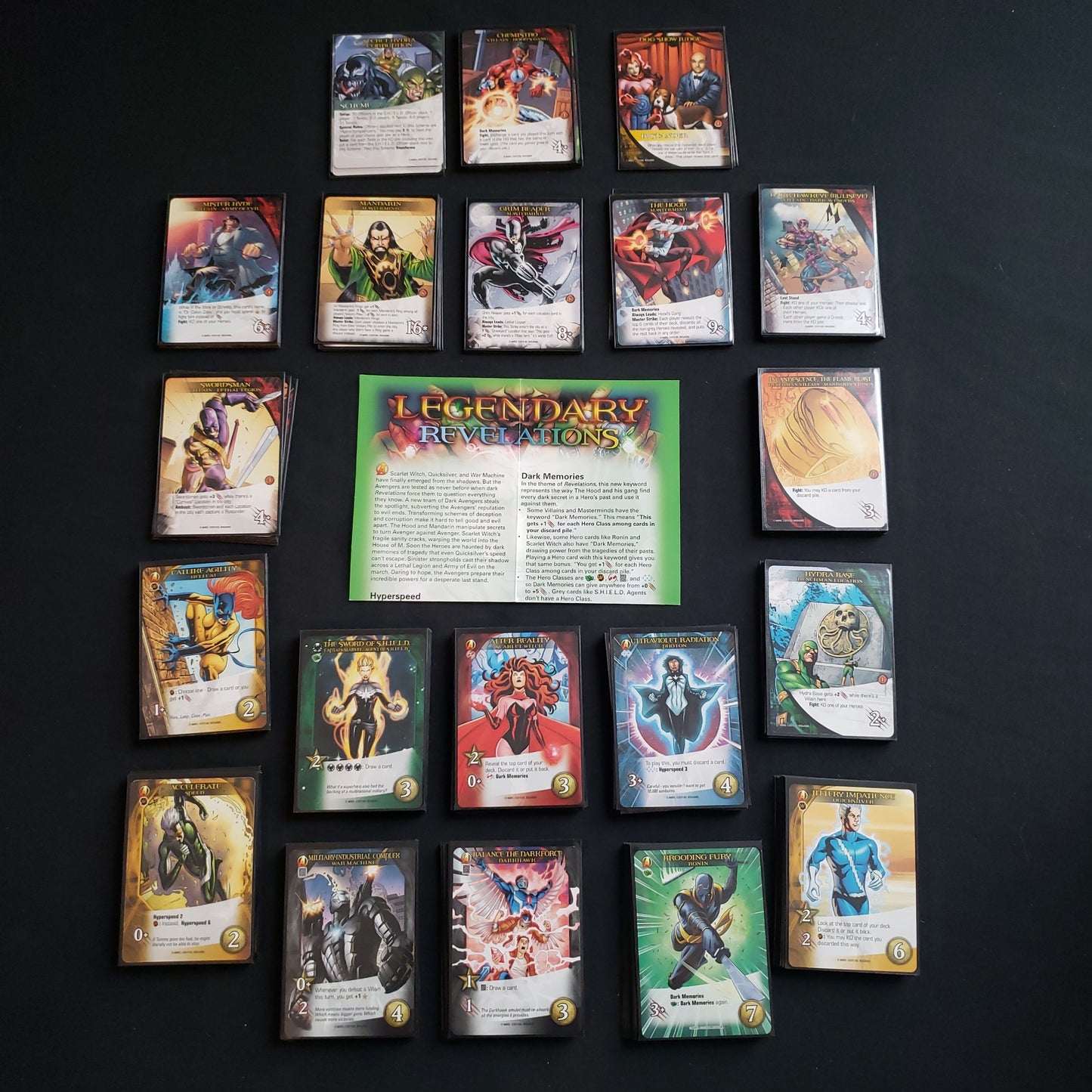 Image shows the instructions & cards arranged in stacks by card type for the Revelations expansion for the board game Legendary Marvel