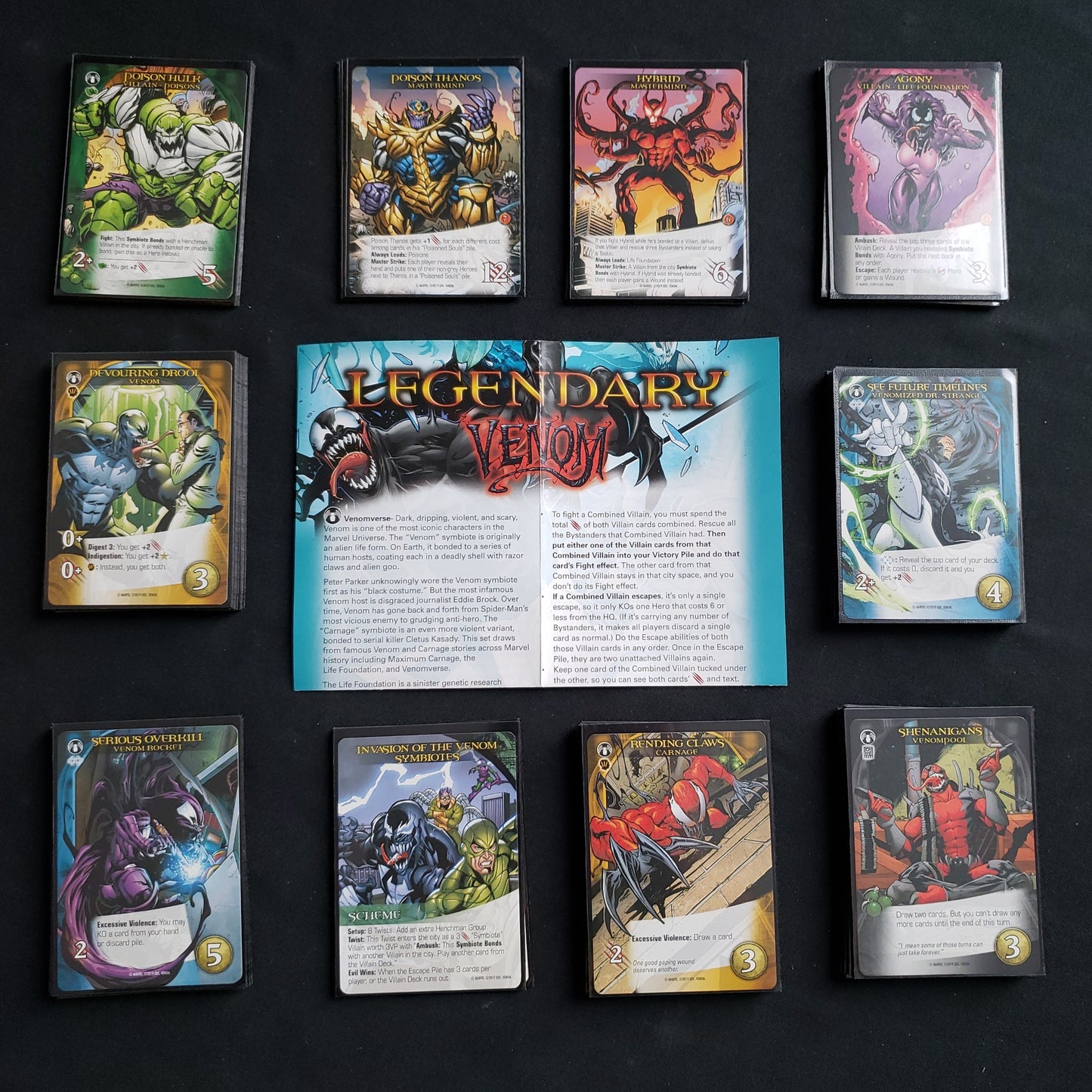 Image shows the instructions & cards arranged in stacks by card type for the Venom expansion for the board game Legendary Marvel