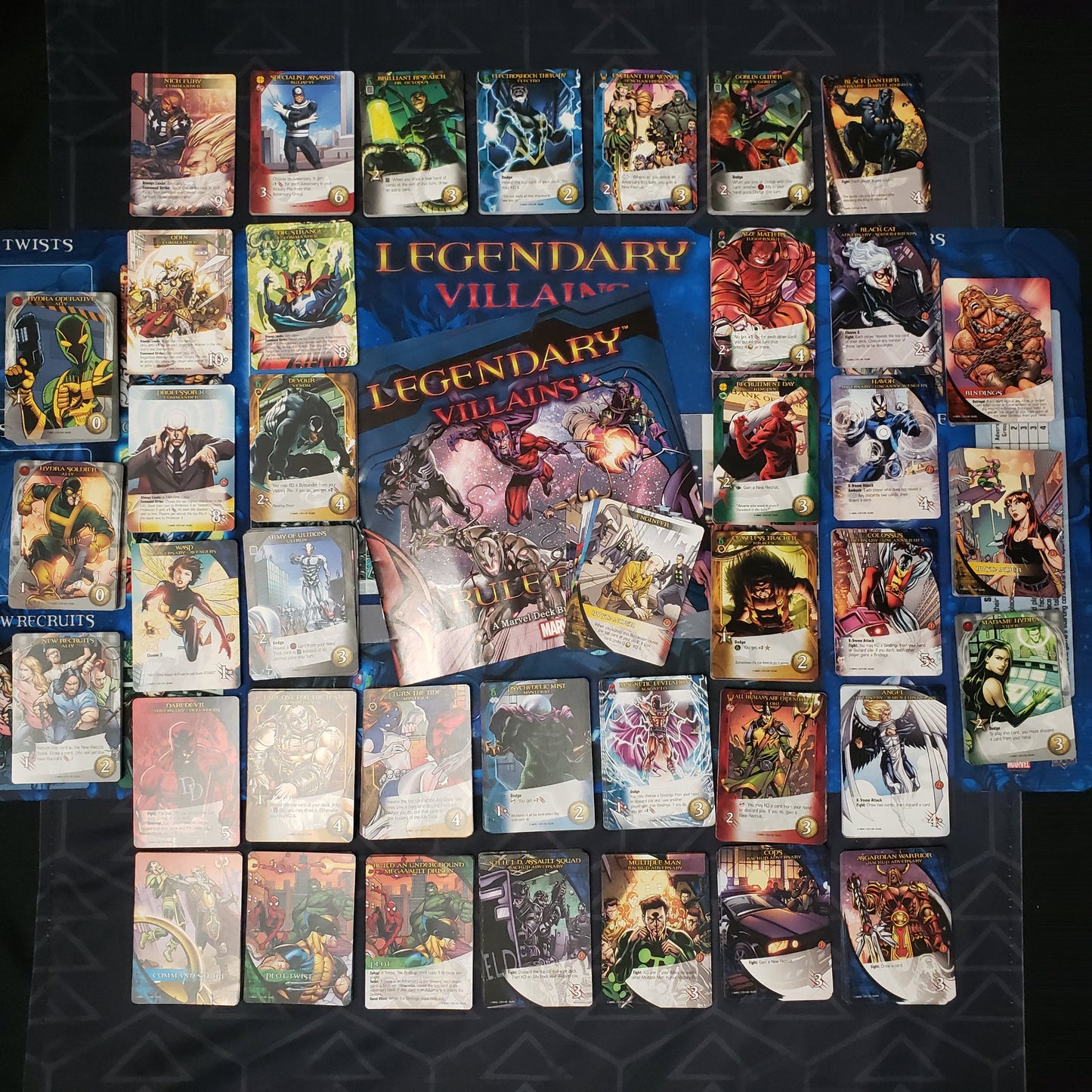 Image shows the playmat, instructions & cards arranged in stacks by card type for the board game Legendary Marvel: Villains