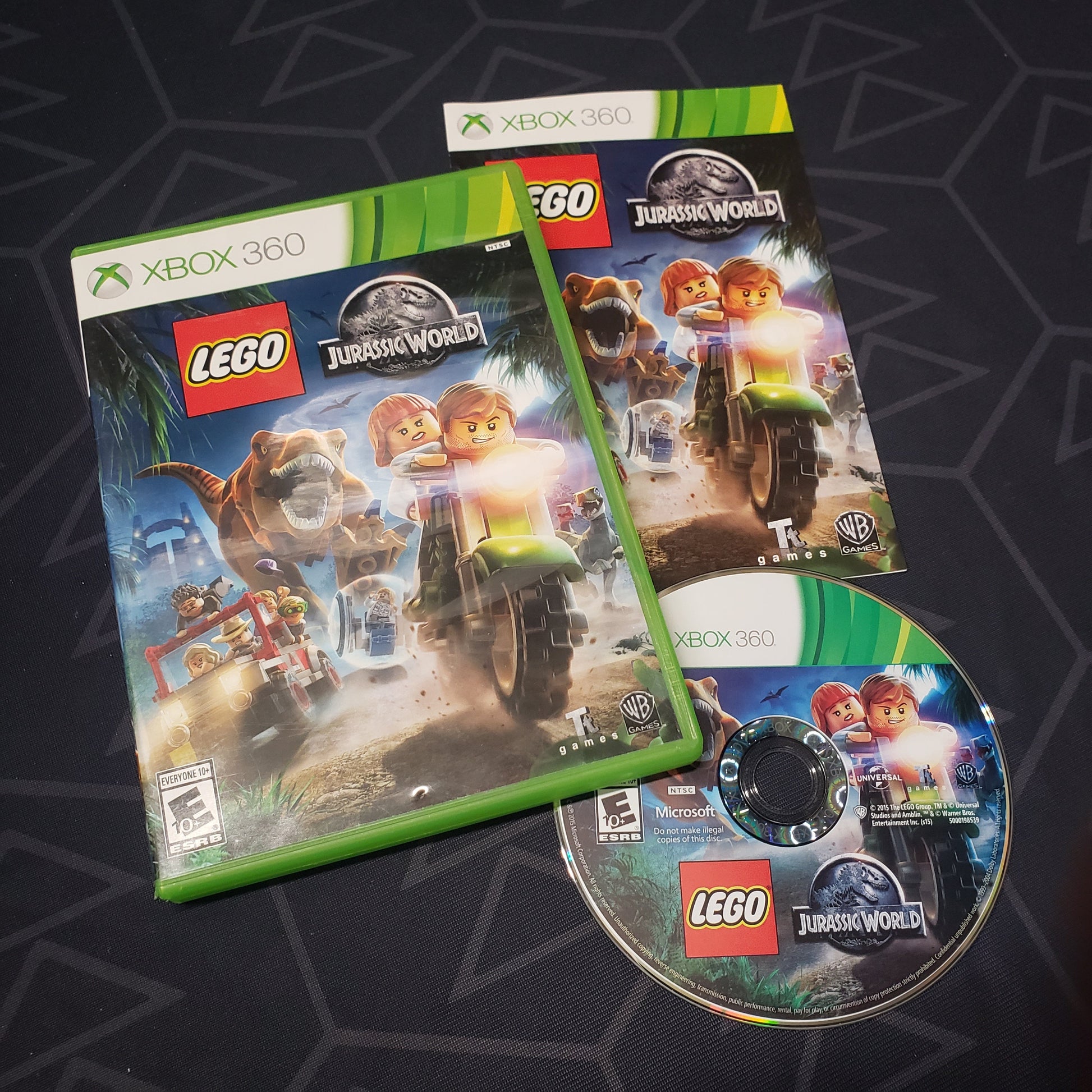 Image shows the case, manual and disc for the video game LEGO Jurassic World for Xbox 360