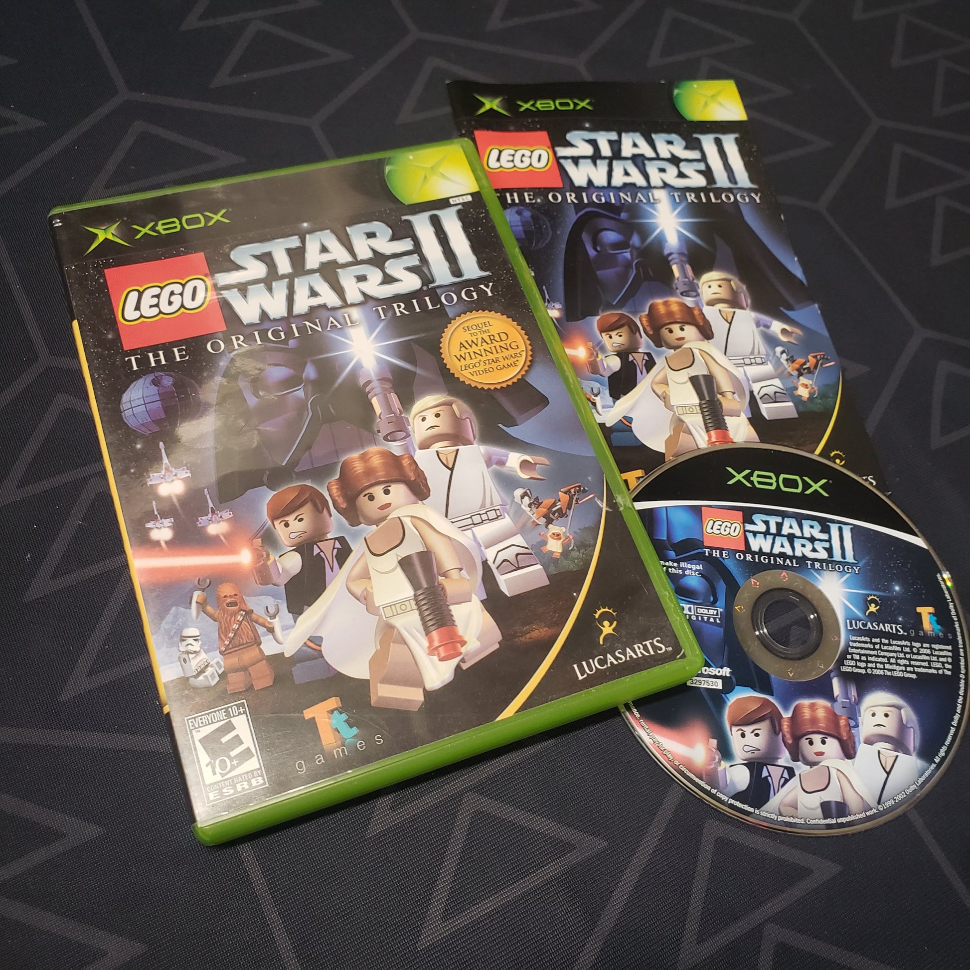 Image shows the case, manual and disc for the video game LEGO Star Wars II: The Original Trilogy for the original Xbox