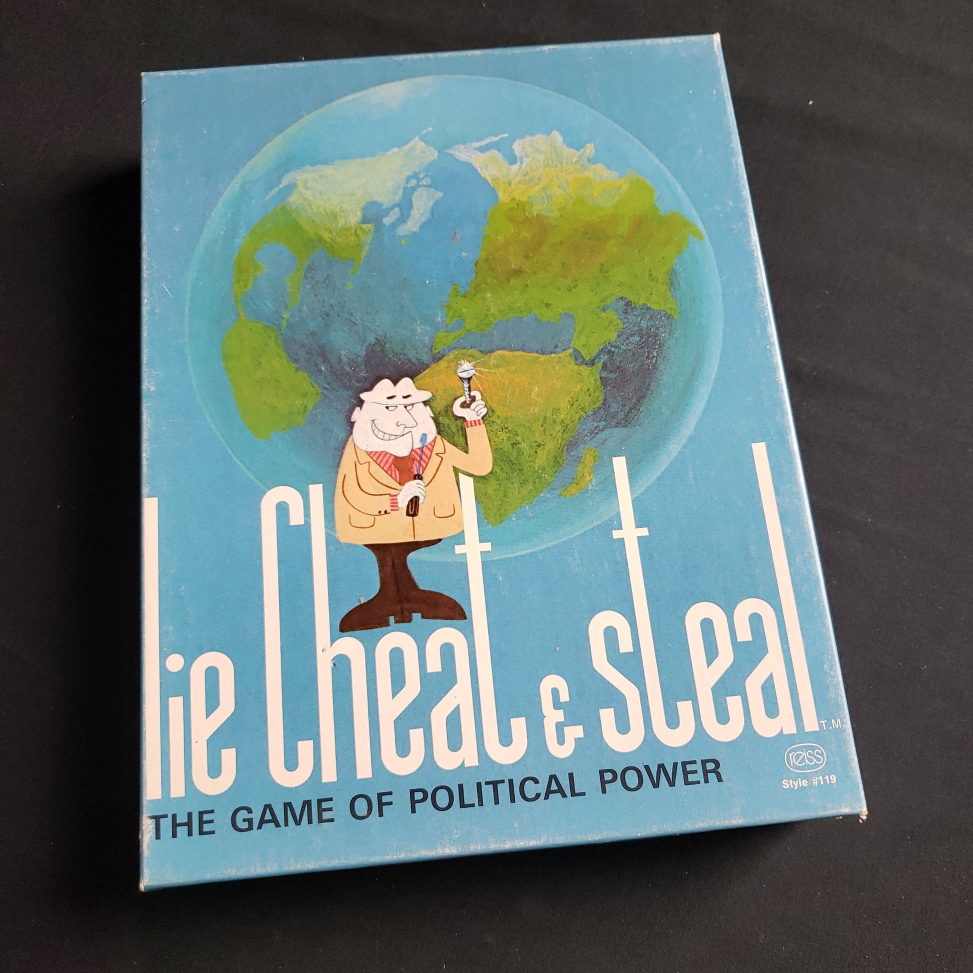 Image shows the front cover of the box of the Lie, Cheat and Steal board game