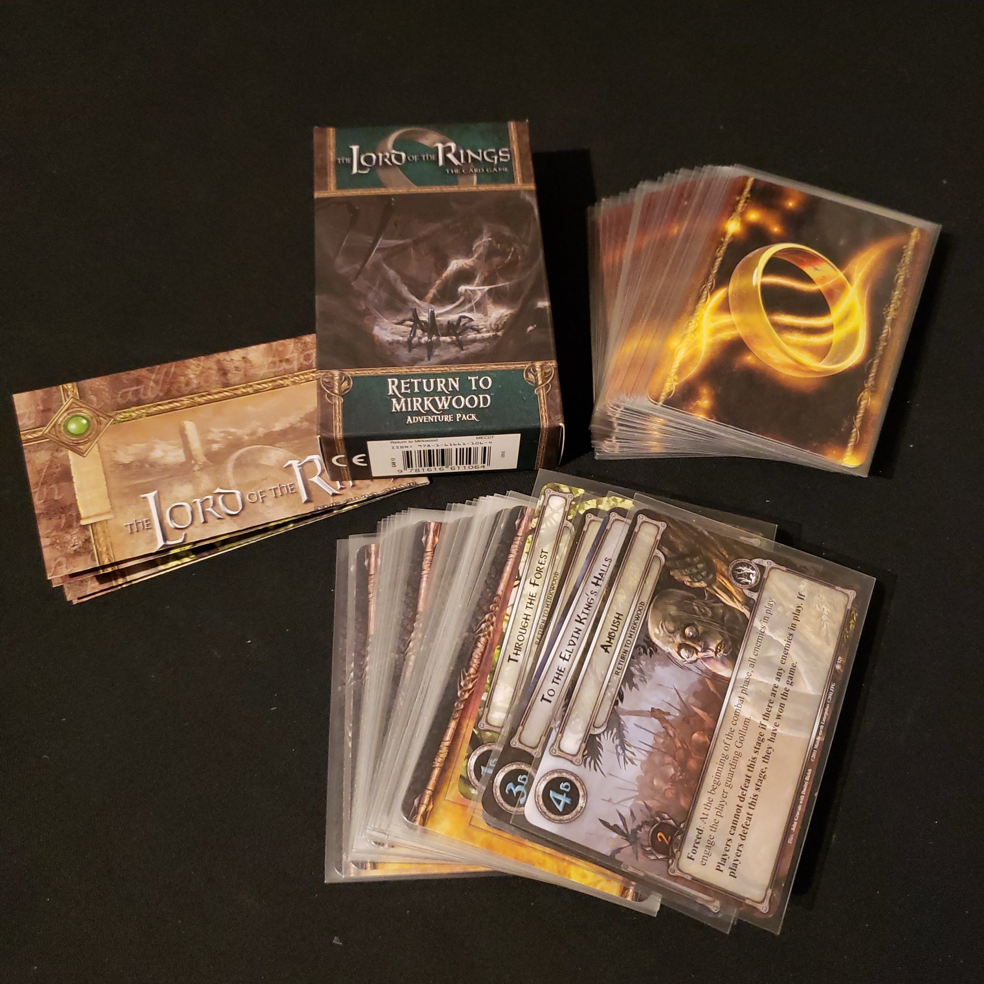 Image shows the front of the package for the Return to Mirkwood Adventure Pack for the Lord of the Rings card game, with the cards and instructions fanned out around it