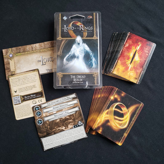 Image shows the front of the package for the Dread Realm Adventure Pack for the Lord of the Rings card game, with the cards and instructions fanned out around it