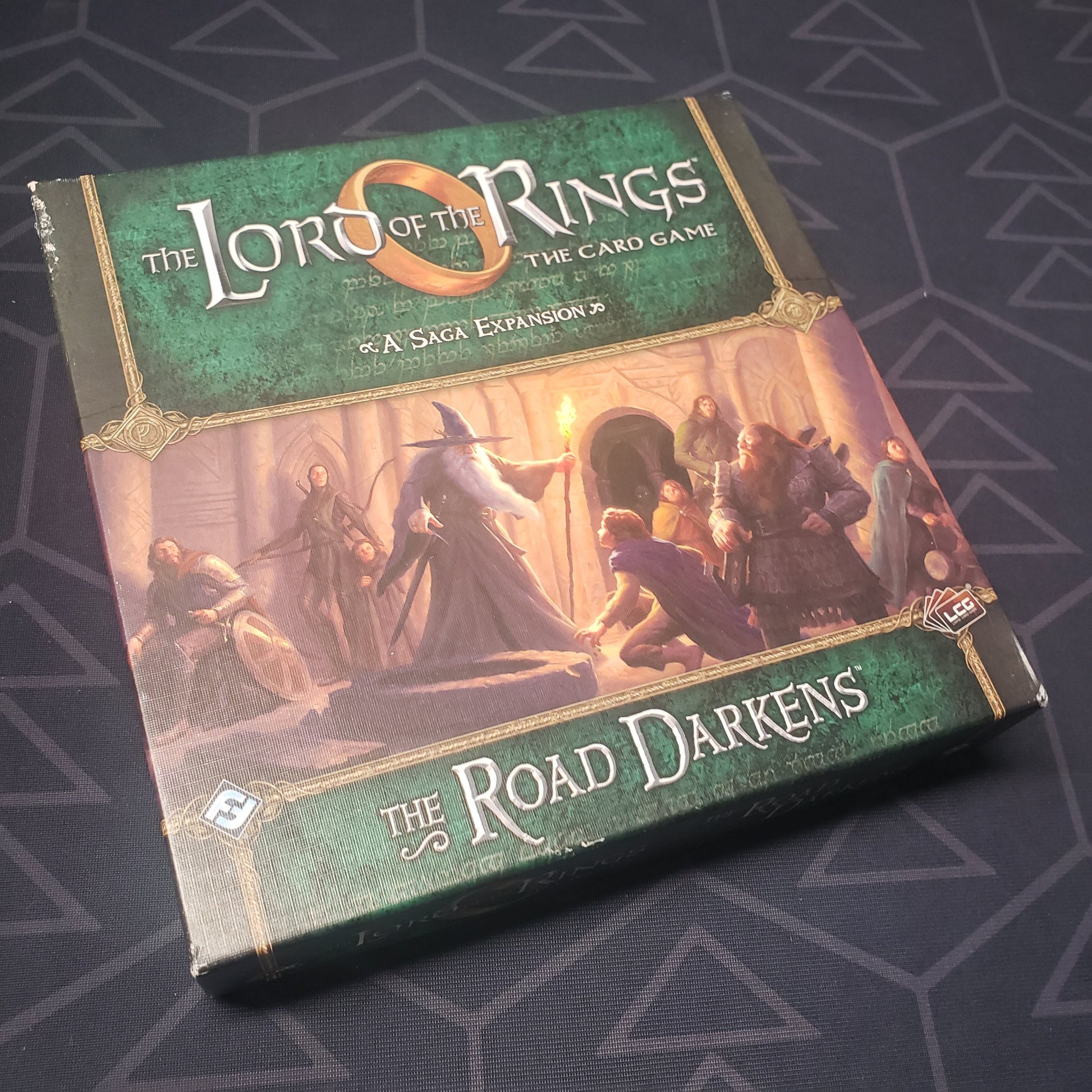 Image shows the front of the box of the Road Darkens Saga expansion for the card game Lord of the Rings
