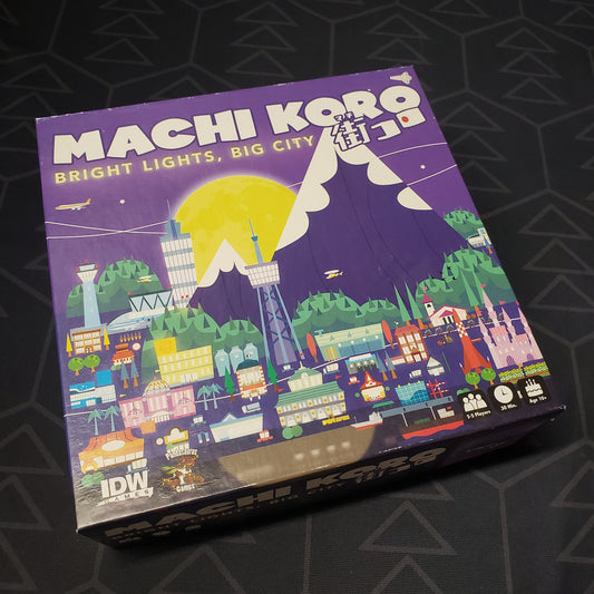 Image shows the front cover of the box of the Machi Koro: Bright Lights, Big City board game