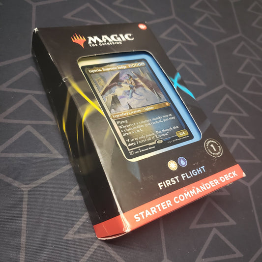 Image shows the front cover of the box of the First Flight: Starter Commander Deck for the card game Magic: The Gathering