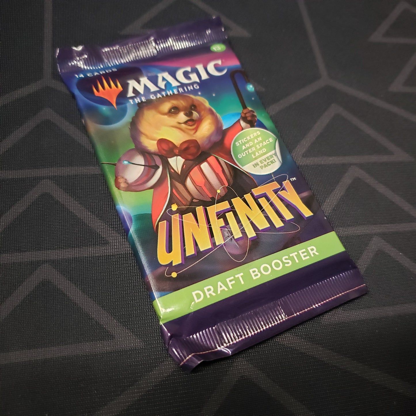 Image shows the front of the packaging of an Unfinity: Draft Booster Pack for the card game Magic the Gathering