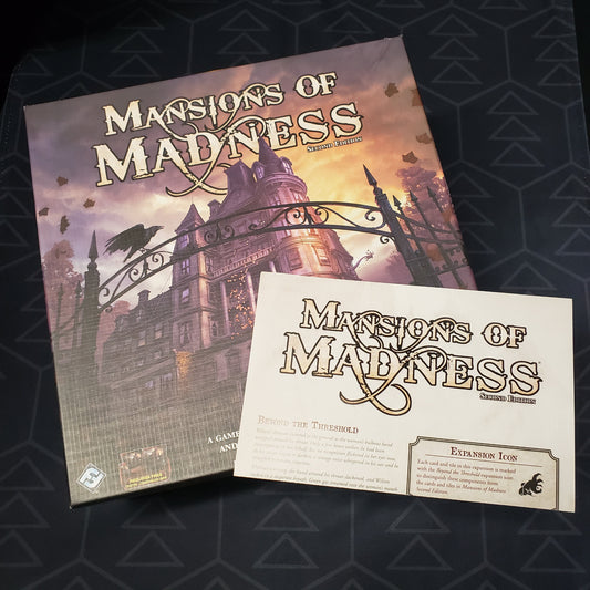 Image shows the front cover of the box of the Mansions of Madness (Second Edition) board game with the instructions for the Beyond the Threshold expansion sitting on top of it