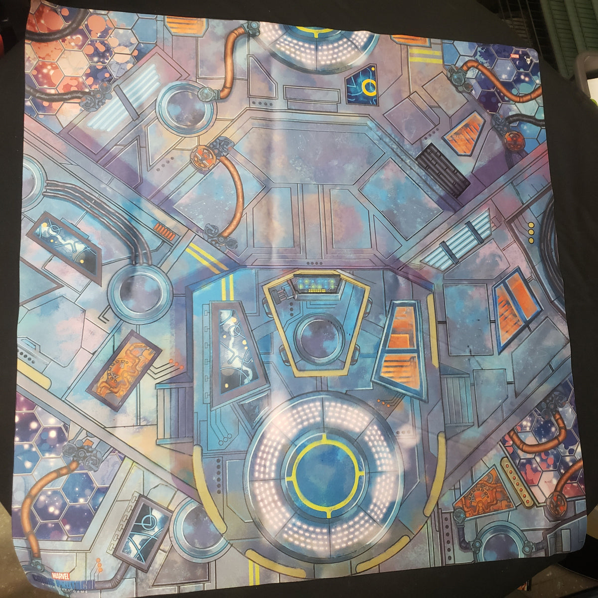 Image shows a sci-fi themed gaming playmat for the miniatures game Marvel Crisis Protocol