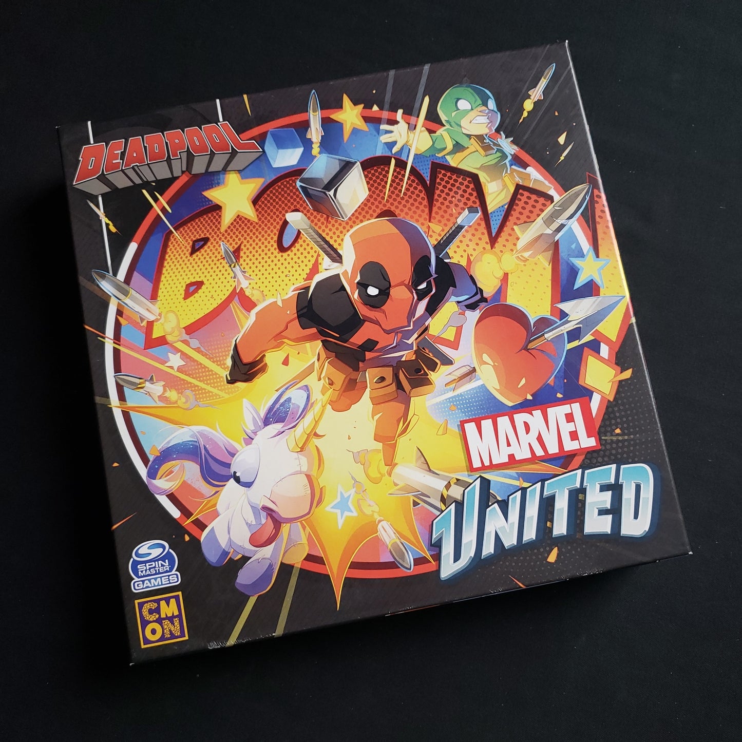 Image shows the front cover of the box of the Deadpool Expansion for the board game Marvel United