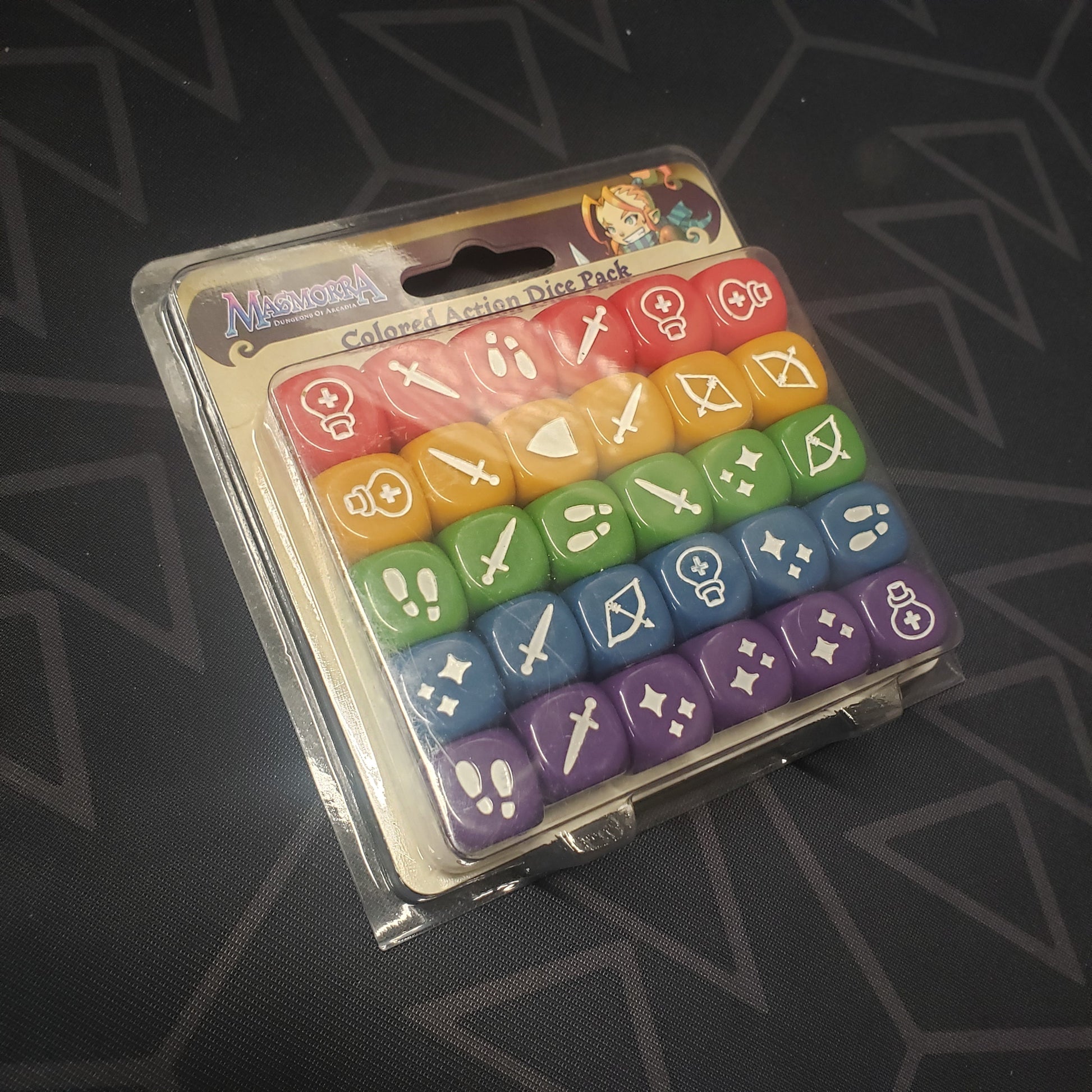 Image shows the front of the packaging of the Colored Action Dice Pack expansion for the board game Masmorra: Dungeons of Arcadia