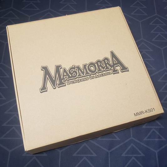 Image shows the front cover of the box of the Kickstarter Exclusives expansion for the board game Masmorra: Dungeons of Arcadia