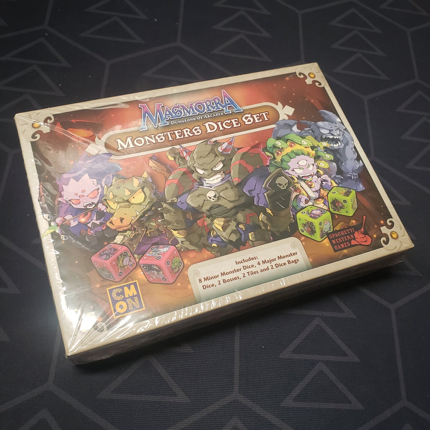 Image shows the front cover of the box of the Monster Dice Set for the board game Masmorra: Dungeons of Arcadia