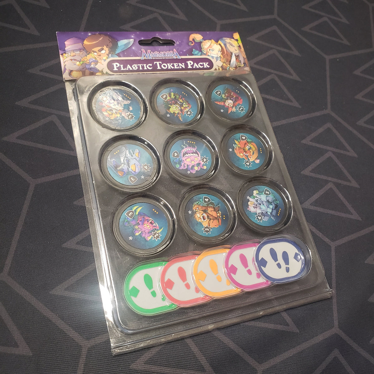 Image shows the front of the packaging of the Plastic Token Pack for the board game Masmorra: Dungeons of Arcadia
