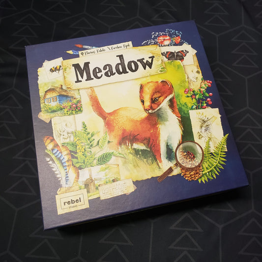Image shows the front cover of the box for the Meadow board game