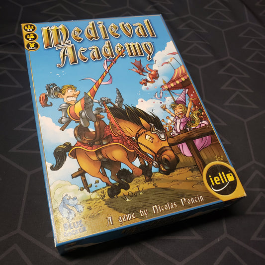 Image shows the front cover of the box for the Medieval Academy card game