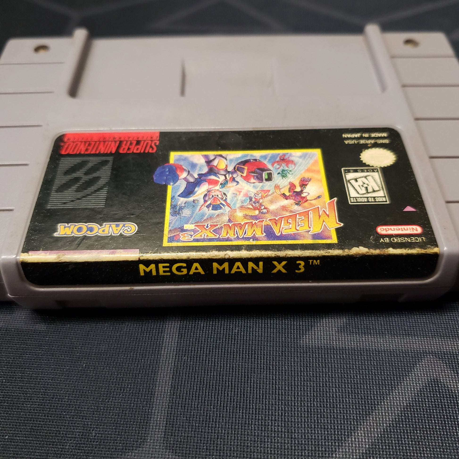 Image shows the wear along the edge of the cartridge label for the video game Mega Man X3 for Super Nintendo