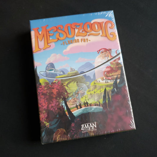 Image shows the front cover of the box of the Mesozooic card game