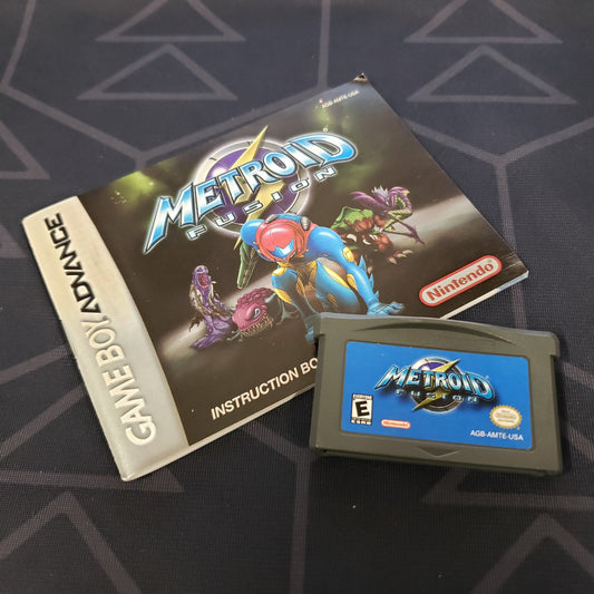 Image shows the manual & cartridge for the video game Metroid Fusion for Nintendo Game Boy Advance