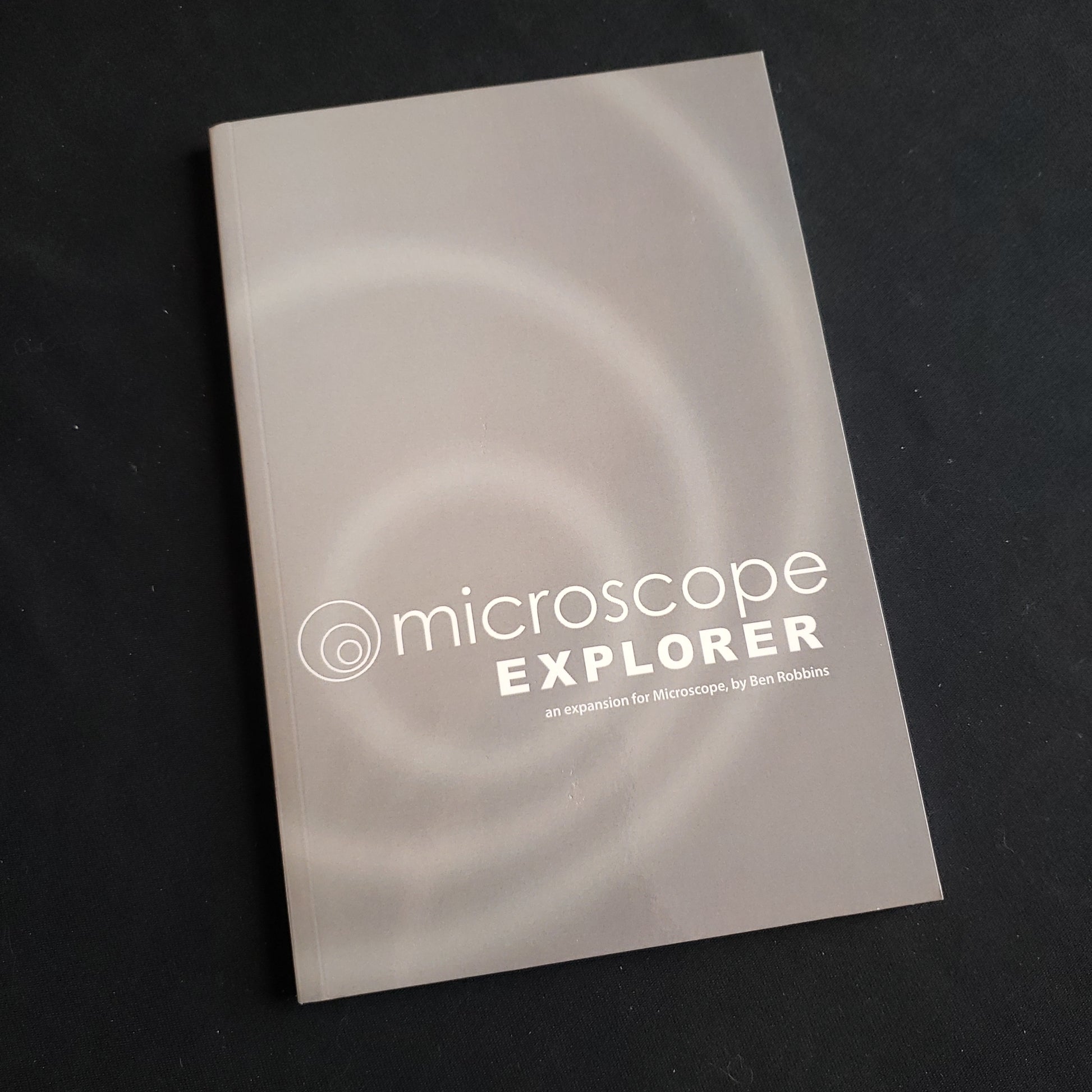 Image shows the front cover of the Microscope Explorer roleplaying game book