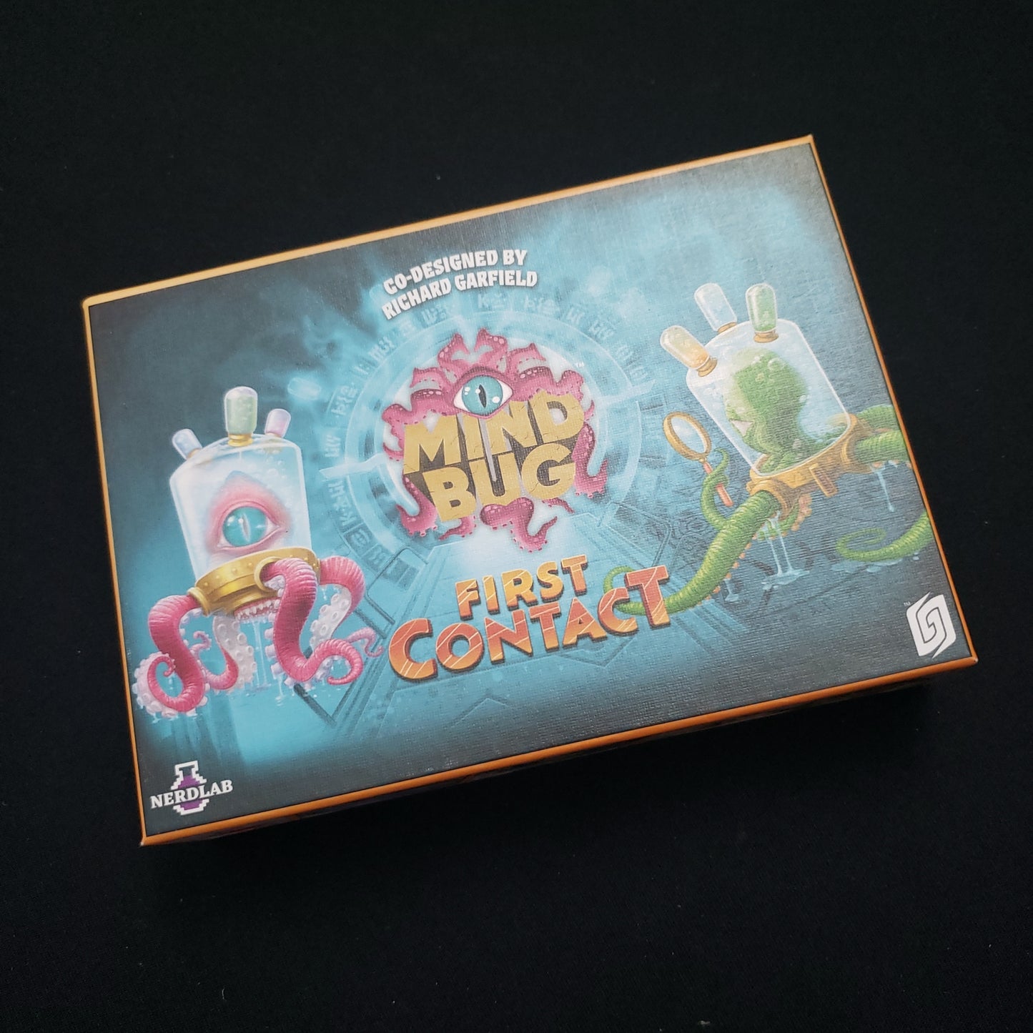 Image shows the front cover of the box of the Mindbug: First Contact card game