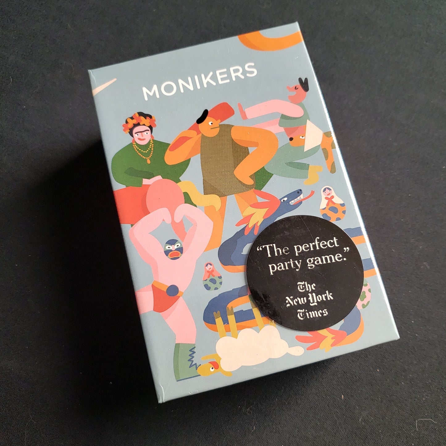 Image shows the front cover of the box of the Monikers party game