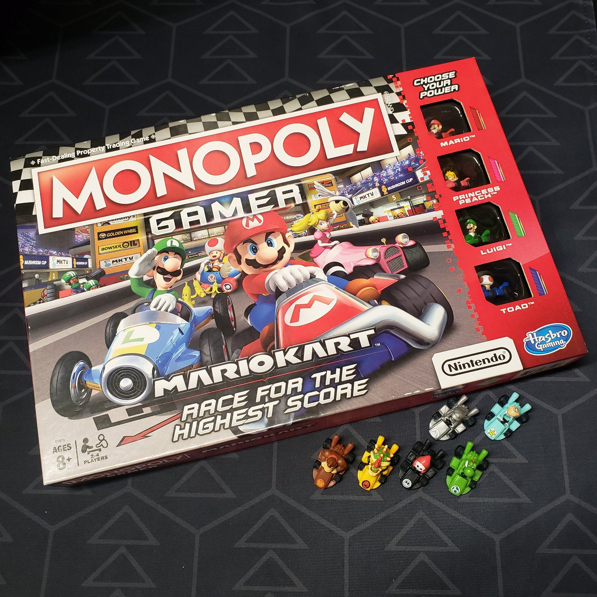 Image shows the front cover of the box of the Monopoly Gamer: Mario Kart board game with six bonus characters sitting underneath it