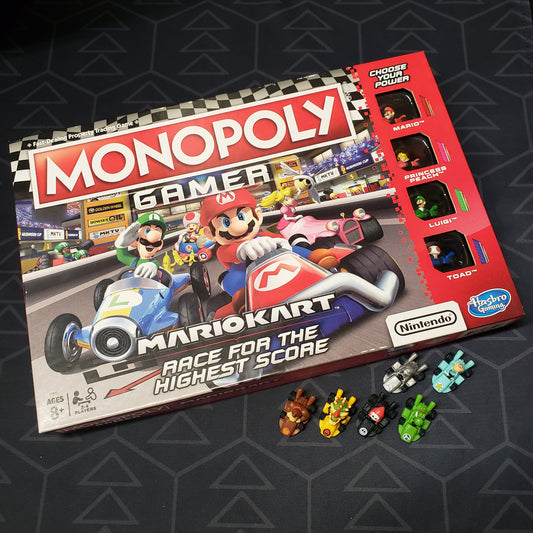 Image shows the front cover of the box of the Monopoly Gamer: Mario Kart board game with six bonus characters sitting underneath it