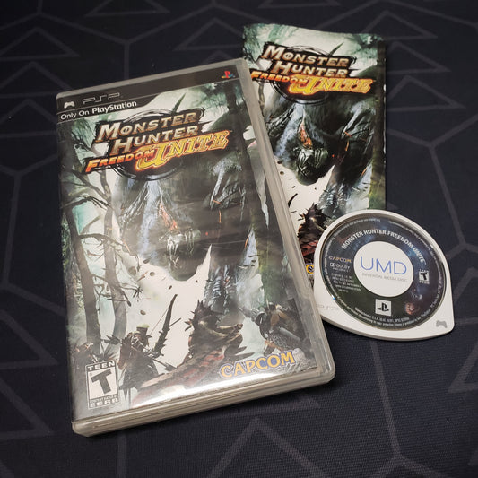 Image shows the case, manual and UMD disc for the video game Monster Hunter: Freedom Unite for Playstation Portable