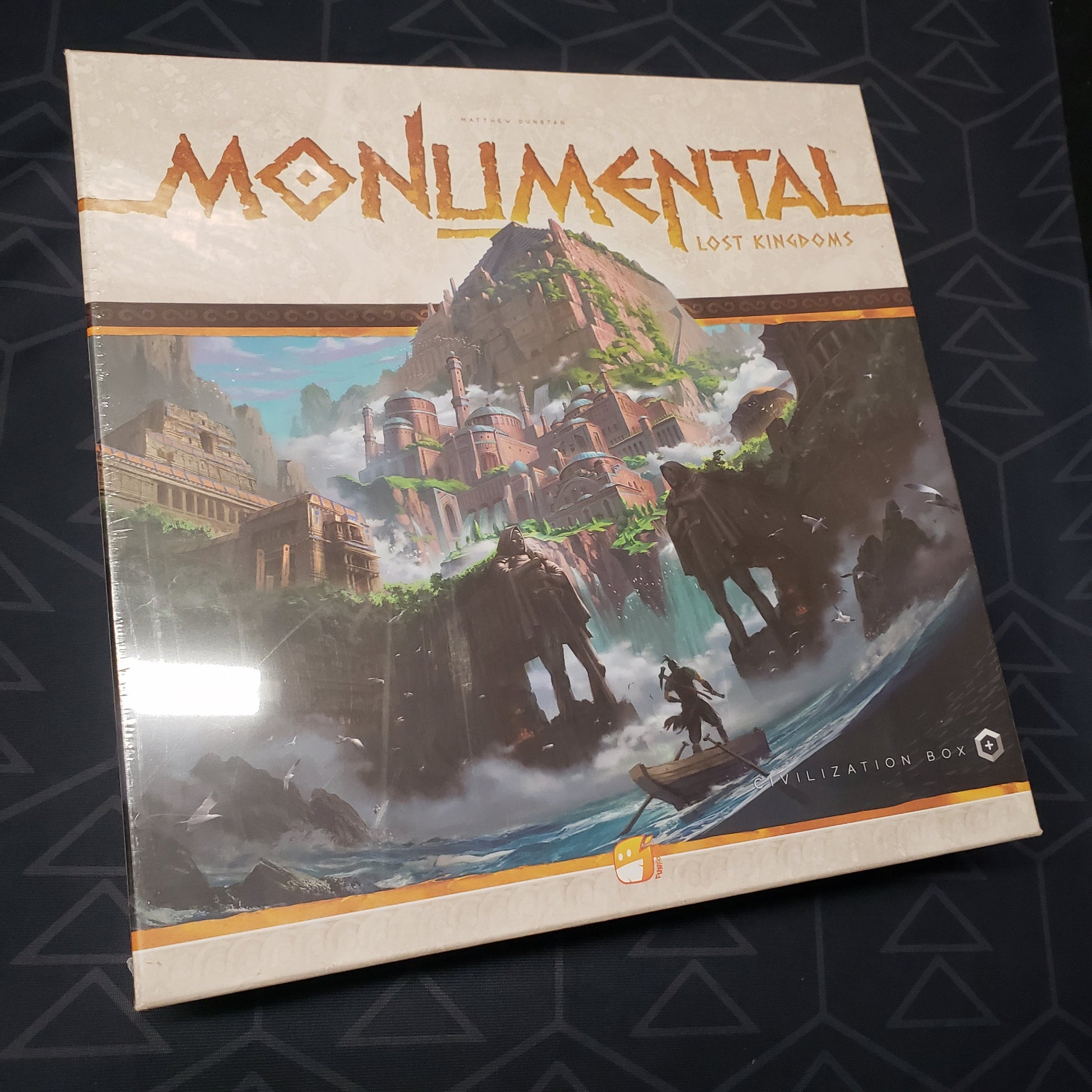Image shows the front cover of the box of the Lost Kingdoms expansion for the board game Monumental