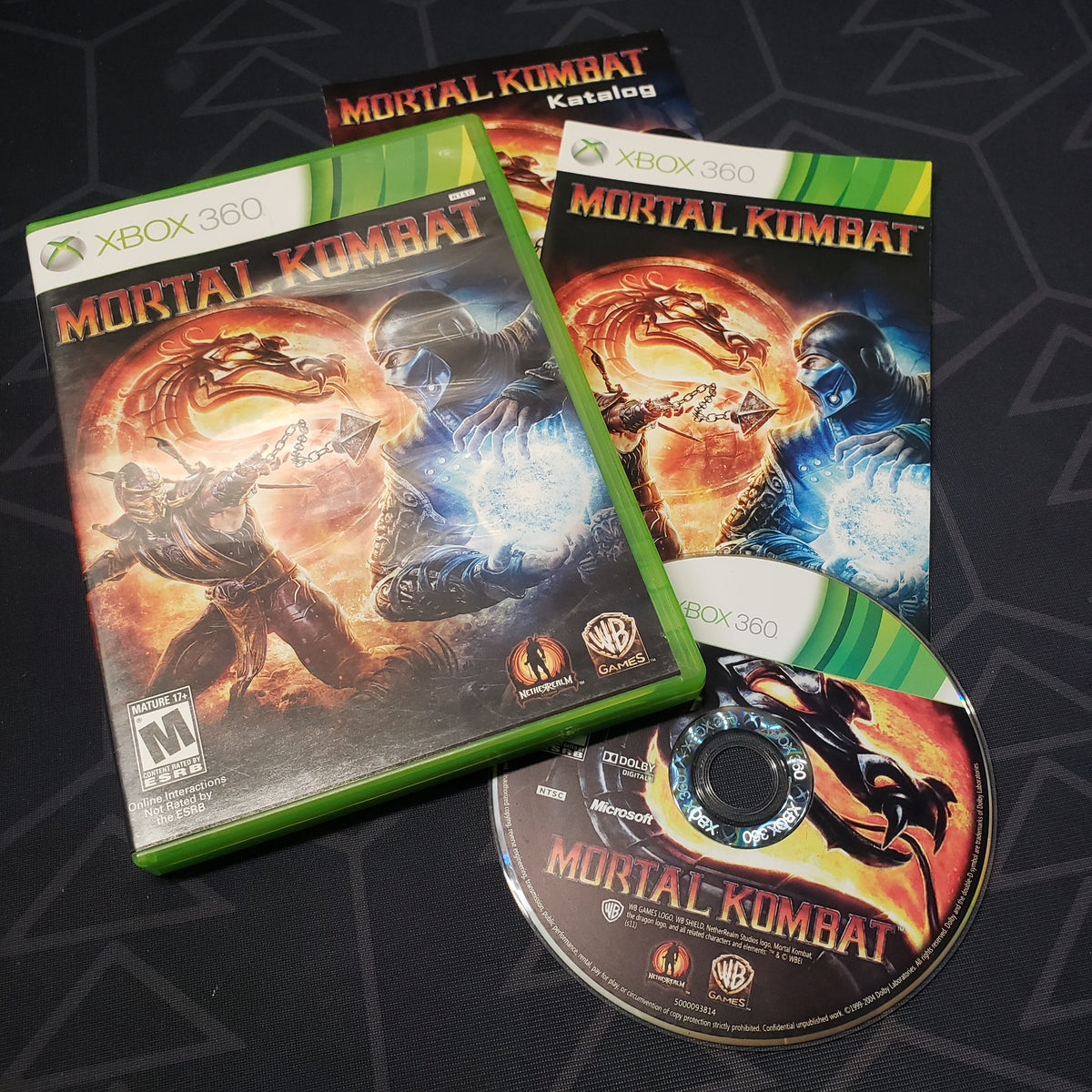 Image shows the case, manual and disc for the video game Mortal Kombat for Xbox 360