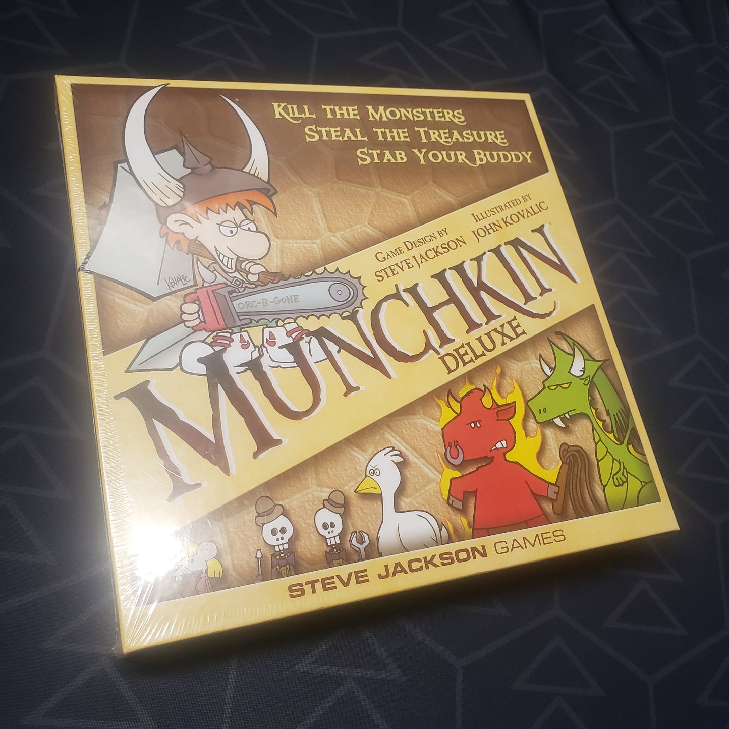 Image shows the front cover of the box of the Munchkin: Deluxe Edition card game